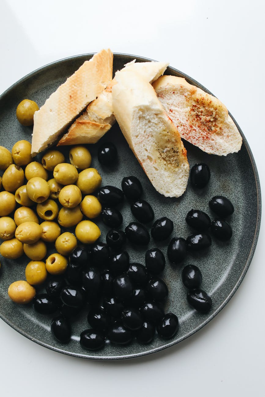 photo of sliced bread beside olives